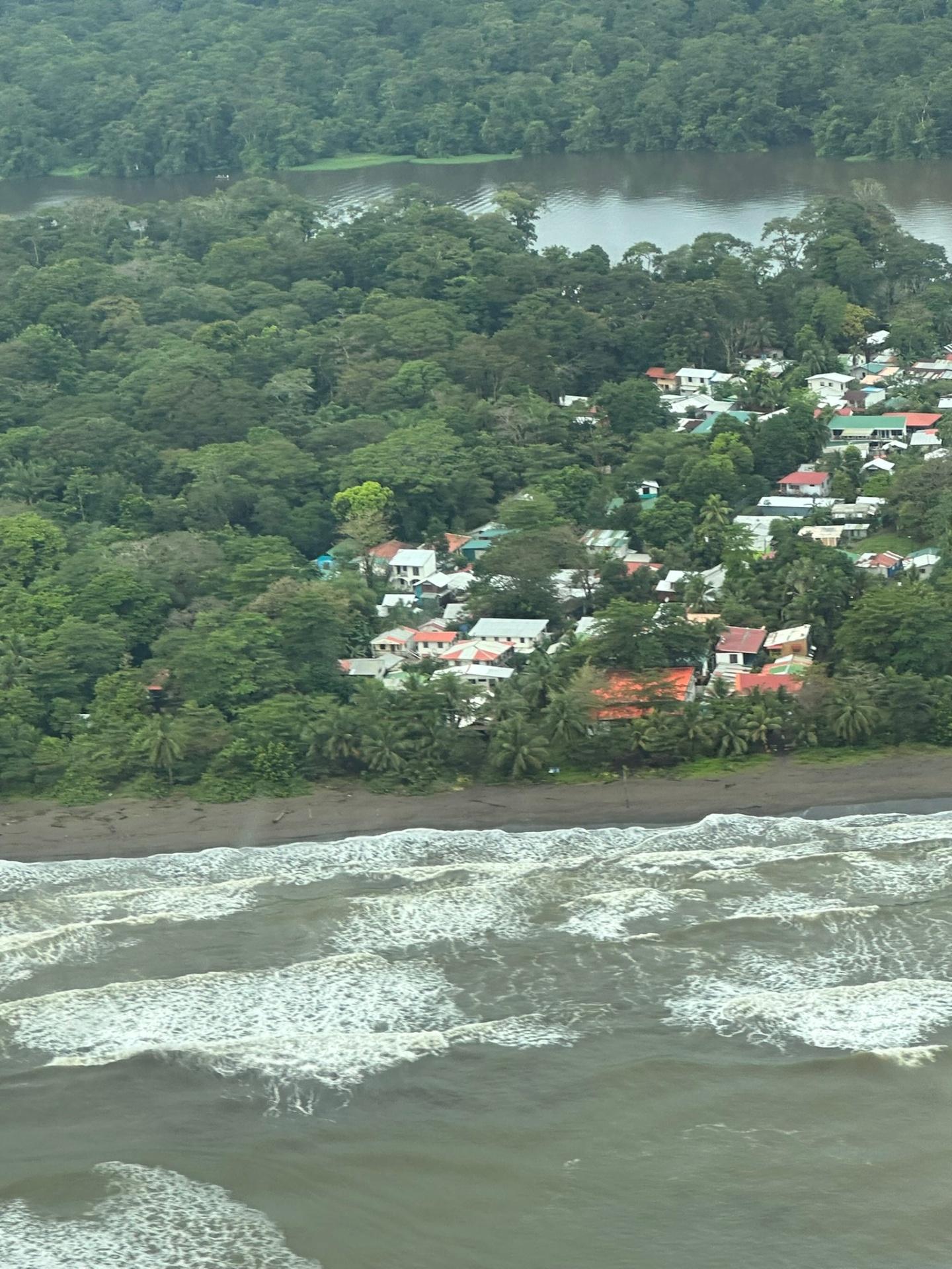 Aerial view of Tortuguero village between Caribbean waves and river