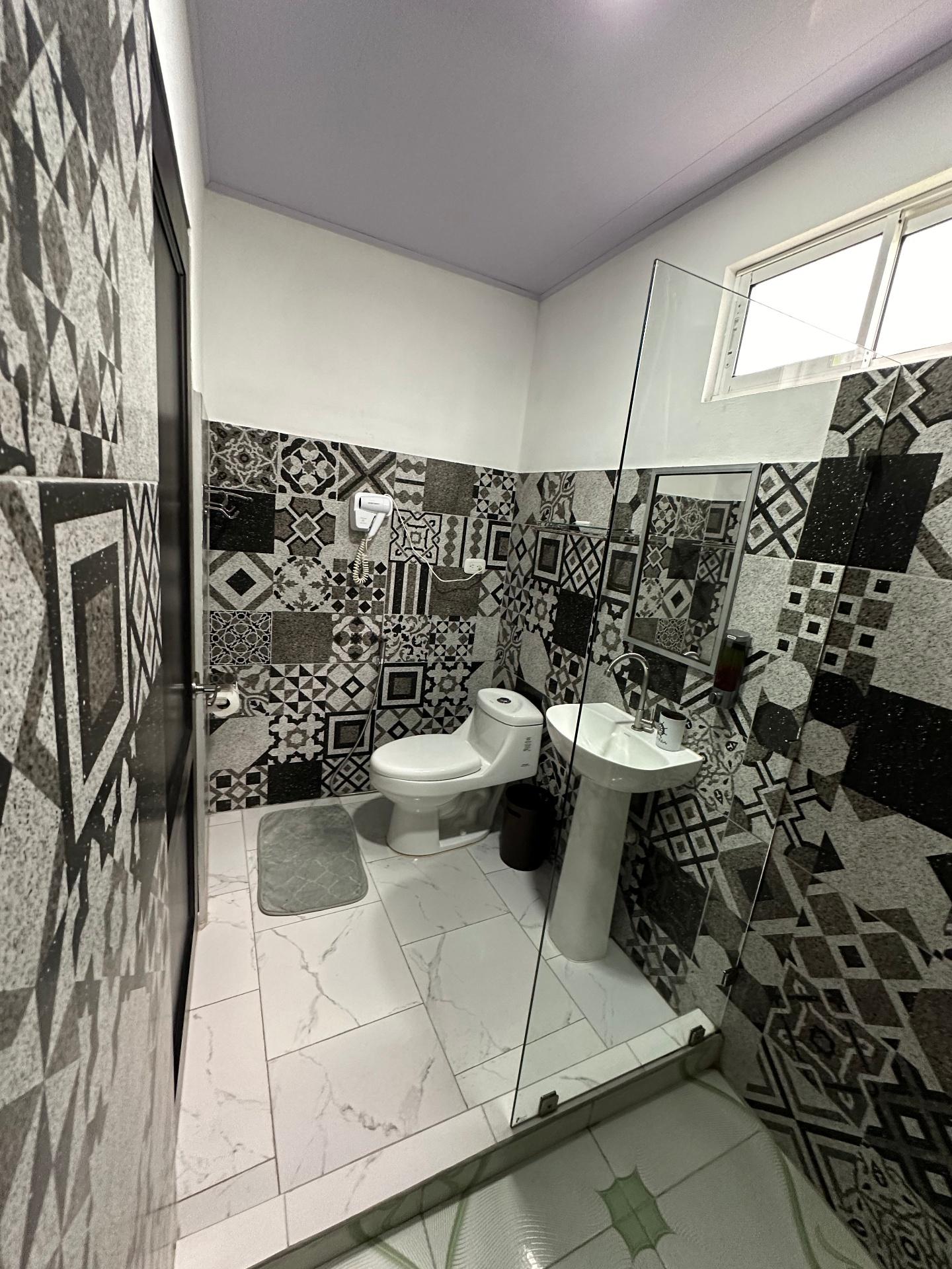 Full bathroom with glass shower and artisan mosaic tiles