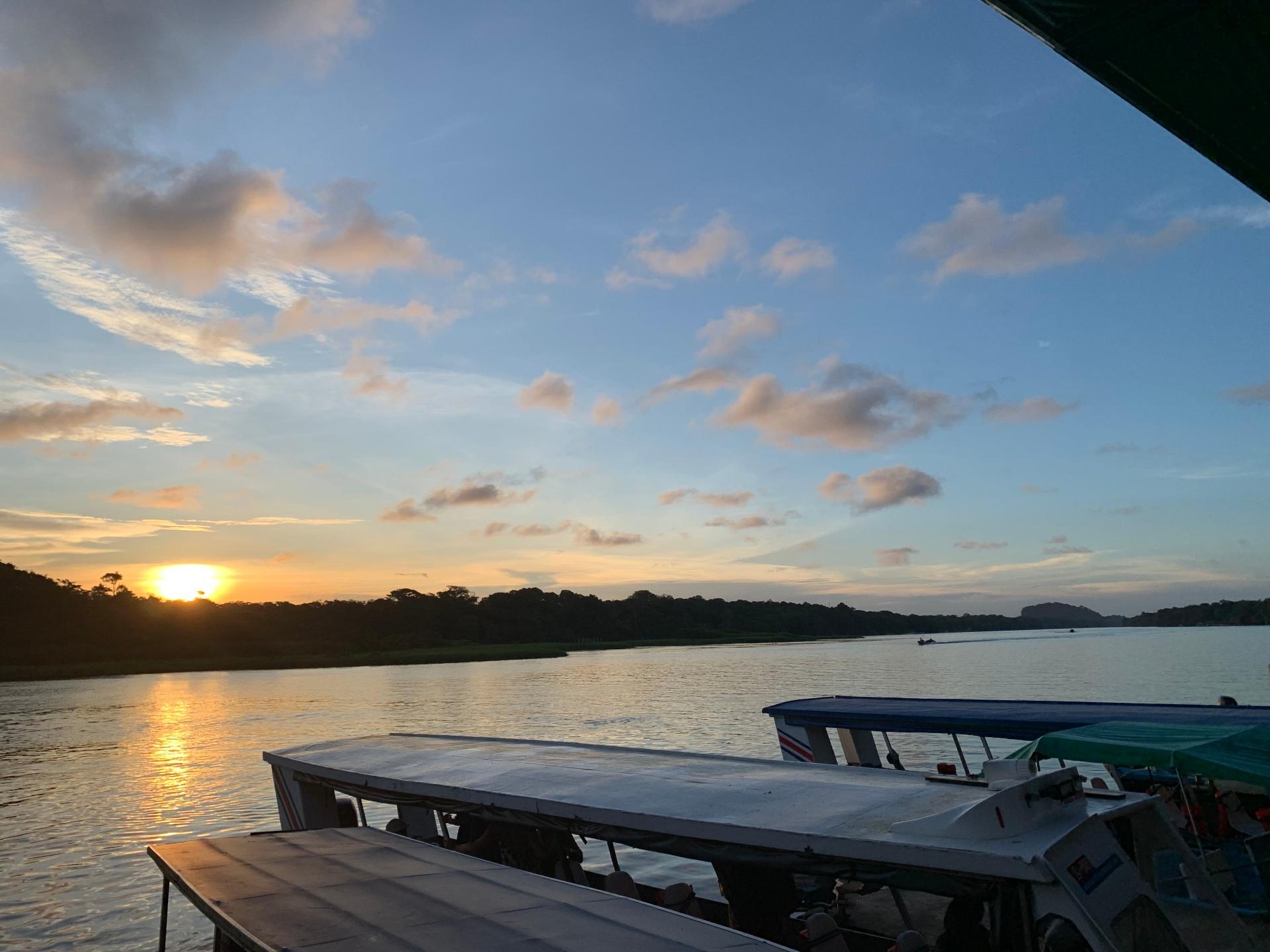 Golden sunset over Tortuguero river with anchored boats