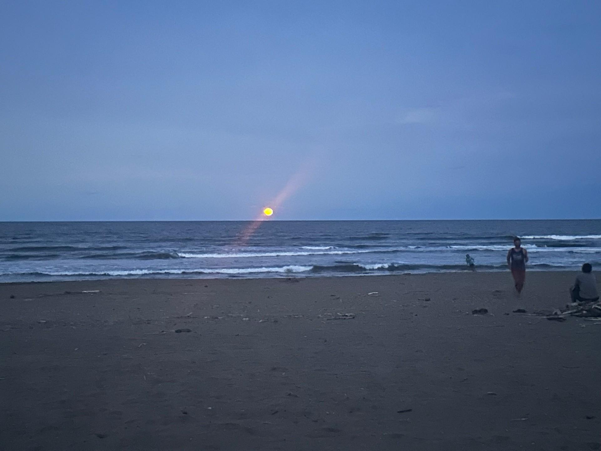 Moonrise over Tortuguero beach with Caribbean waves at dusk